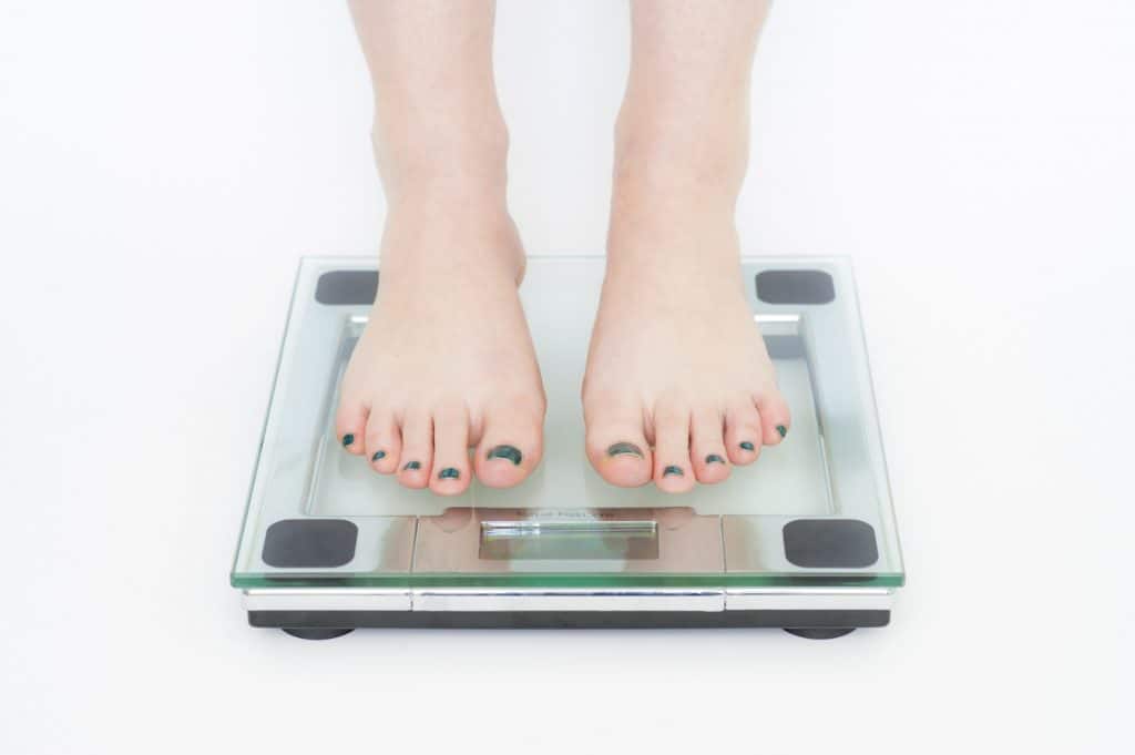 Les pieds d'une femme sur une balance mesurant son poids.