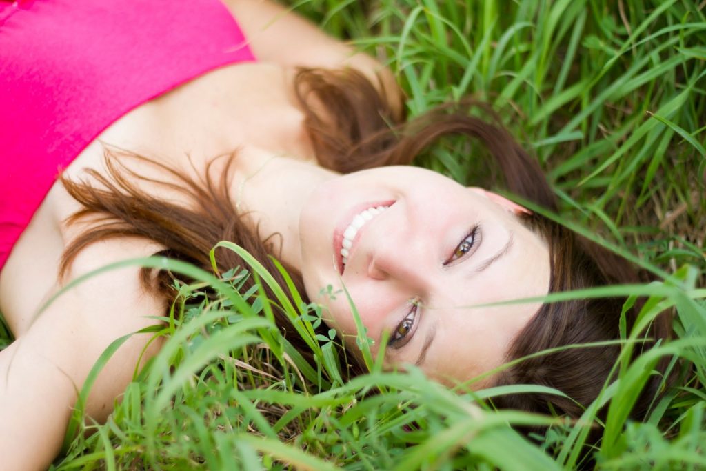 Giovane donna sdraiata sull'erba