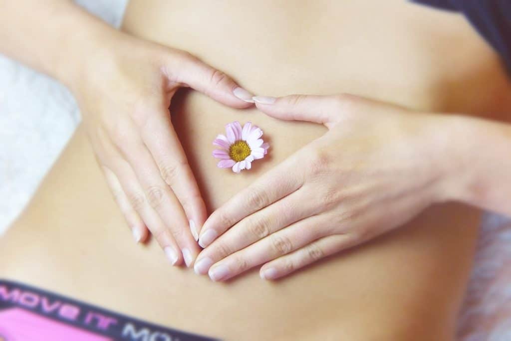 Une femme tenant une fleur sur son ventre, tout en faisant la promotion d'un laxatif amaigrissant.