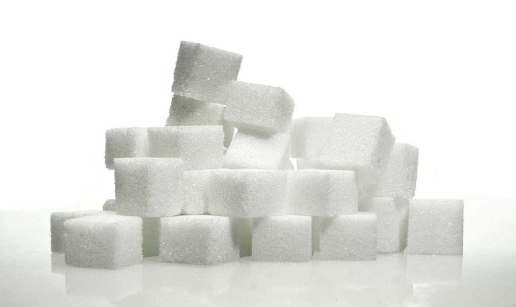 Una pila di zollette di zucchero su sfondo bianco, perfette per chi segue un regime sans sucre.
