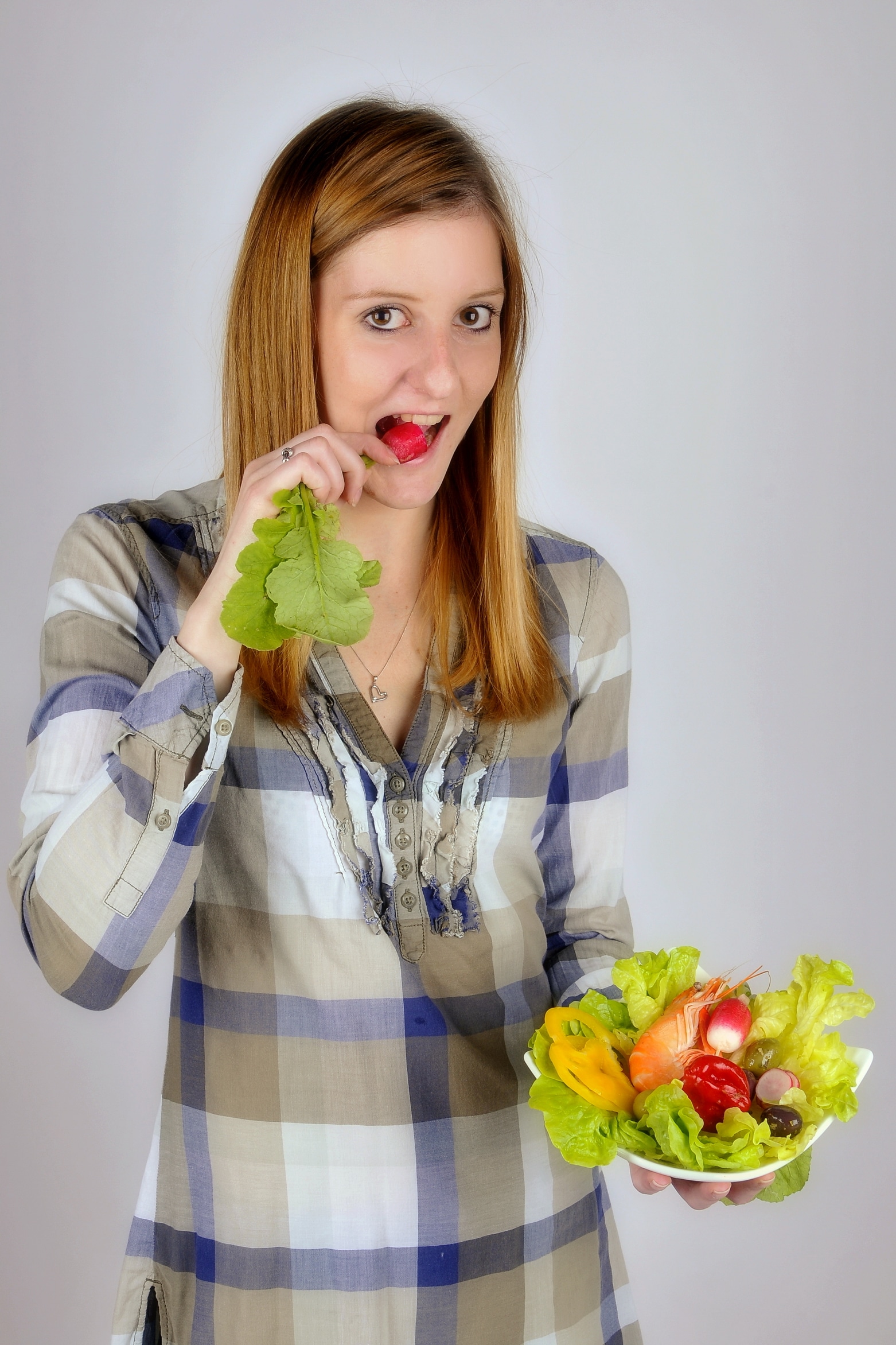 Una donna tiene in mano una ciotola di insalata.