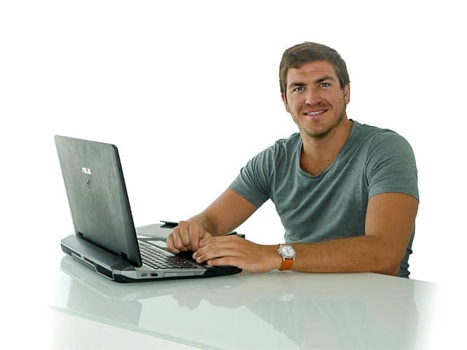 Un uomo seduto alla scrivania con un computer portatile.