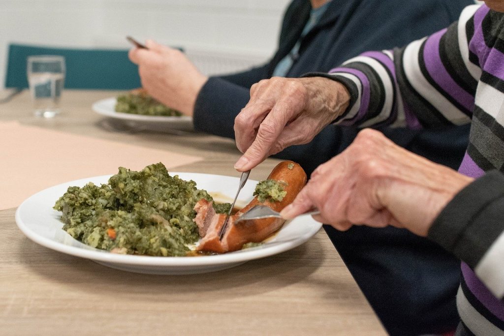 Una donna sta mangiando un piatto di cibo con una forchetta.