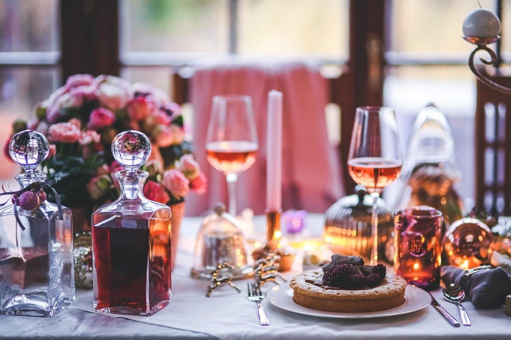 Una tavola apparecchiata per una cena con vino e fiori.